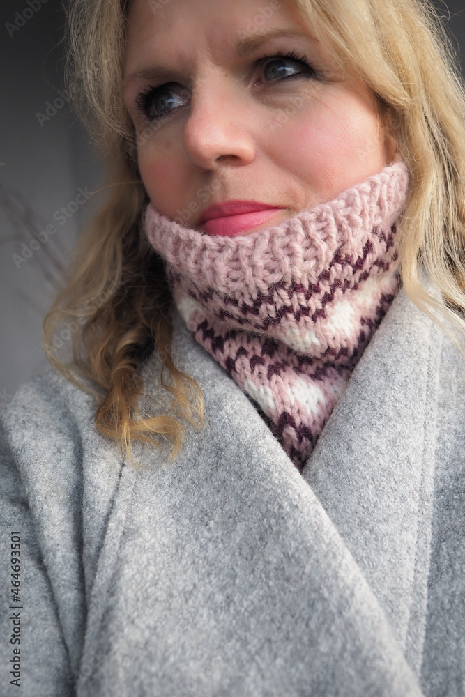 mature woman keeping warm in a hand knit scarf mature woman keeping warm in a hand knit scarf
