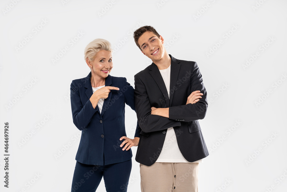 Handsome teen boy posing with his elegant mom on white studio background Handsome teen boy posing with his elegant mom on white studio background