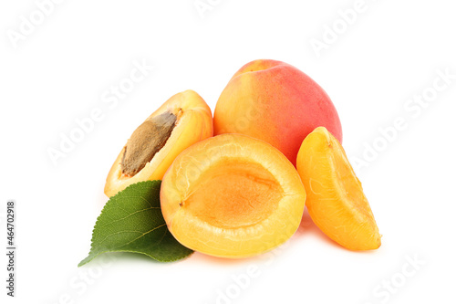 Apricot halves with seed and green leaf isolated on white background