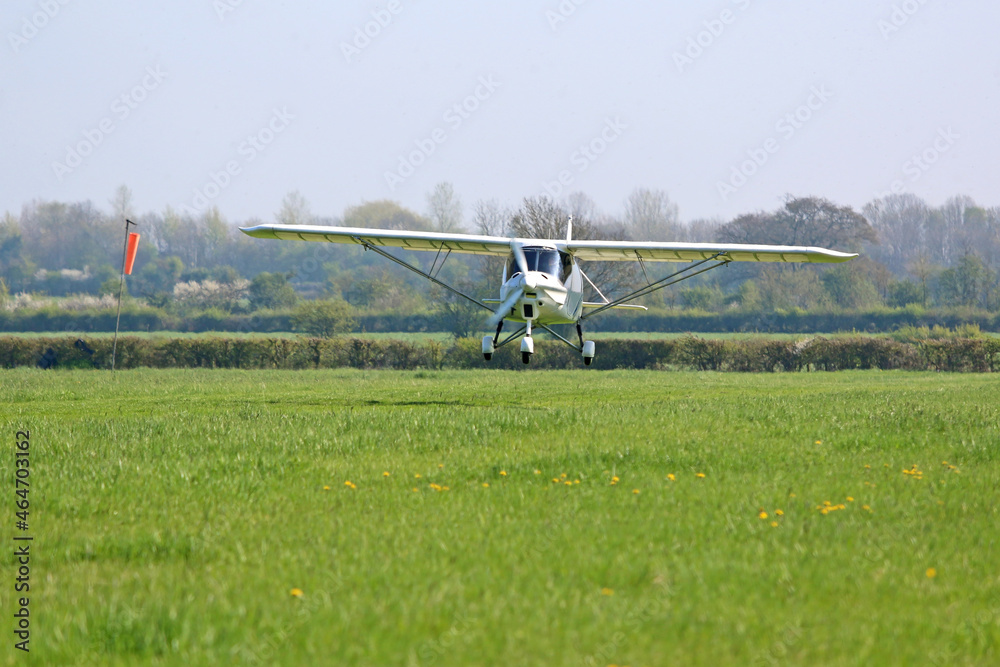 Ultralight airplane taking off from a grass strip Ultralight airplane taking off from a grass strip