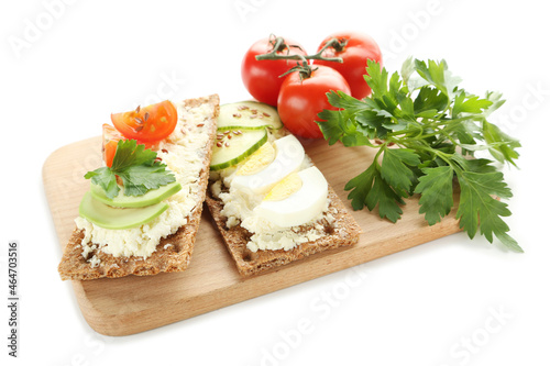 Crispbread with cream cheese, eggs and vegetables on white background