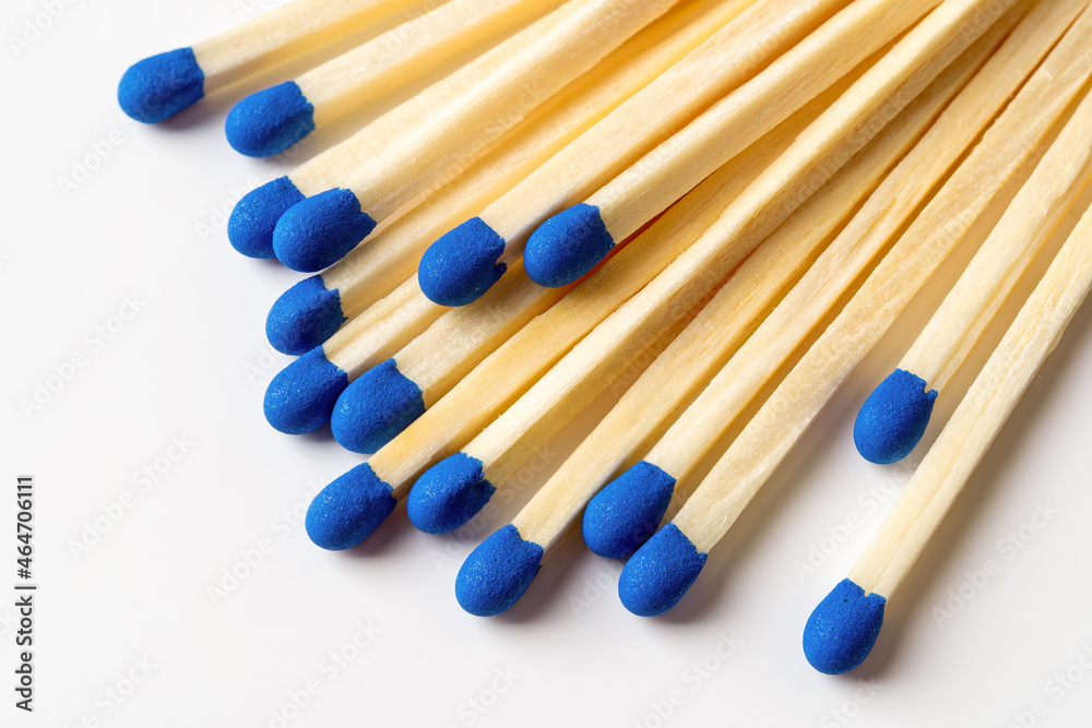 Blue wooden matches on a light gray background. Matchsticks with bright blue heads macro. Scattered wooden matches without box close-up. Design element for smoker accessory concept. Blue wooden matches on a light gray background. Matchsticks with bright blue heads macro. Scattered wooden matches without box close-up. Design element for smoker accessory concept.
