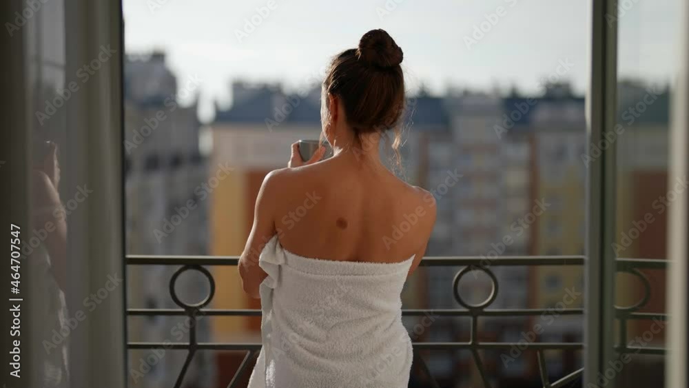 attractive slender woman meets the day on the balcony of her apartment with a cup of invigorating coffee attractive slender woman meets the day on the balcony of her apartment with a cup of invigorating coffee