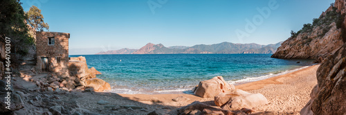 Panoramic view of a derelict building on the small secluded beach of Ficaghiola and turquoise Mediterranean sea on the west coast of Corsica