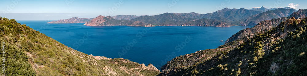Panoramic view of the Gulf of Porto on the west coast of Corsica with mountains including Paglia Orba and Monte Senino in the distance