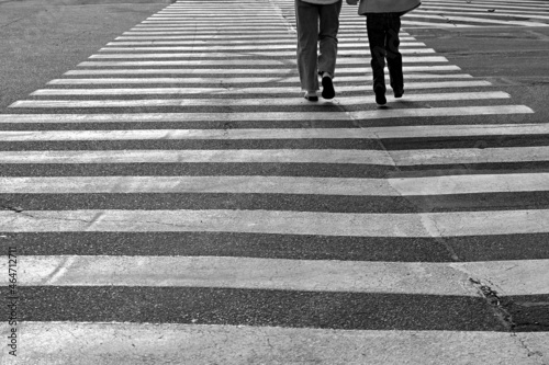 People on white stripes of pedestrian crossing in black and white image