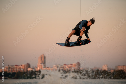 wonderful view of male wakeboarder while jumping in the air on wakeboard © fesenko