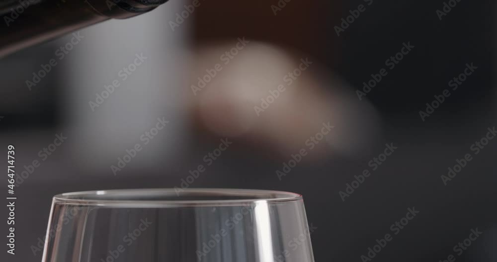 Slow motion pour red wine into wineglass closeup indoor shot
