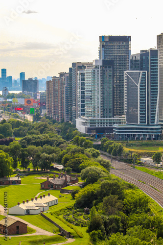 Aerial view of Fort York with lush green fields, urban forest, and skyscrapers