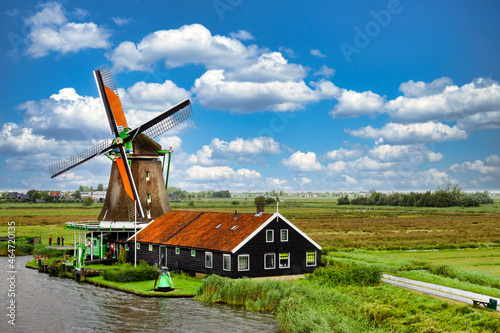 Rural landscape with windmill in Zaanse Schans. Holland, Netherlands. Authentic Zaandam mill. Beautiful Netherland landscape. Photo stock.