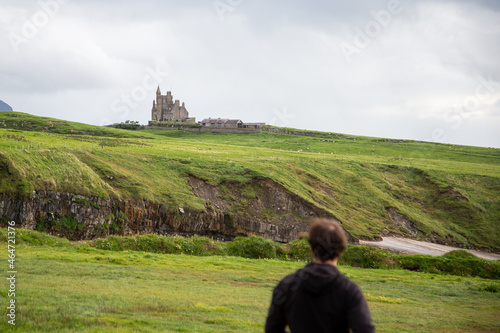 A man looking at Classiebawn Castle from a coastal viewpoint, County Sligo, Ireland photo