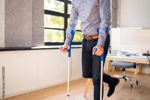 Tela Worker With Crutches At Workplace Or Office