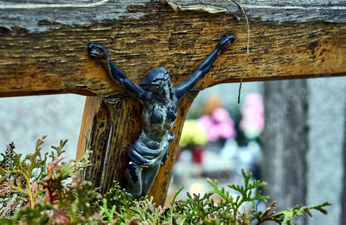 Figurine of crucified Jesus on a grave in a cemetery © GKor