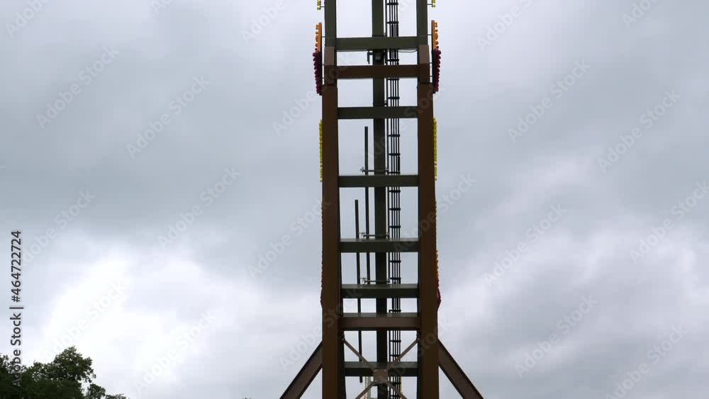 Outdoor amusement ride with large wheel sliding up and spinning, low angle view. Outdoor amusement ride with large wheel sliding up and spinning, low angle view.