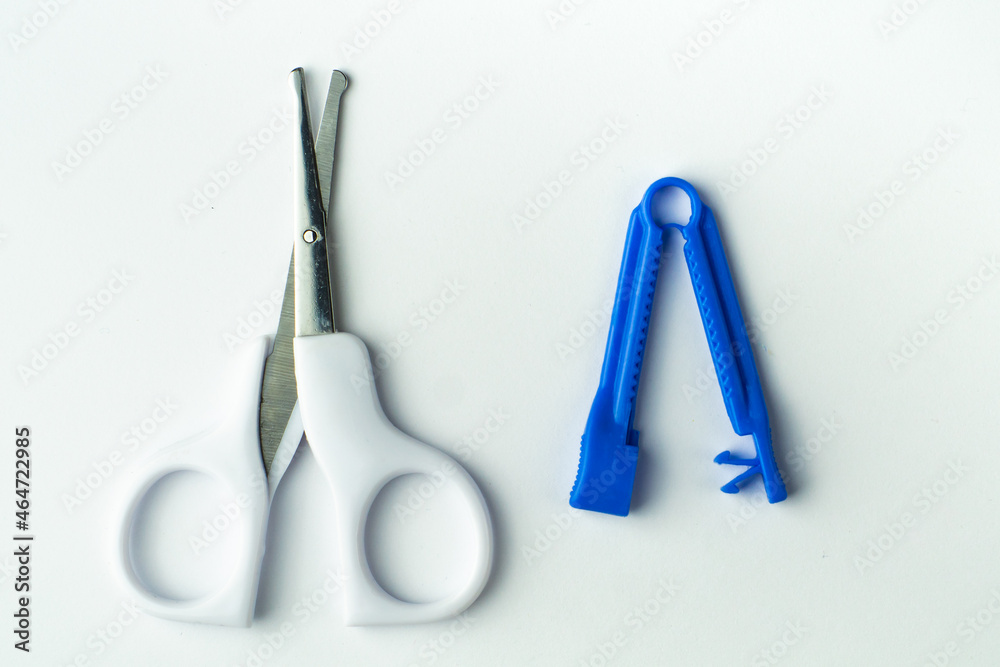 sterile scissors and umbilical cord clamp on white background. Birth at home, cutting umbilical cord concept.