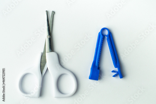 sterile scissors and umbilical cord clamp on white background. Birth at home, cutting umbilical cord concept.