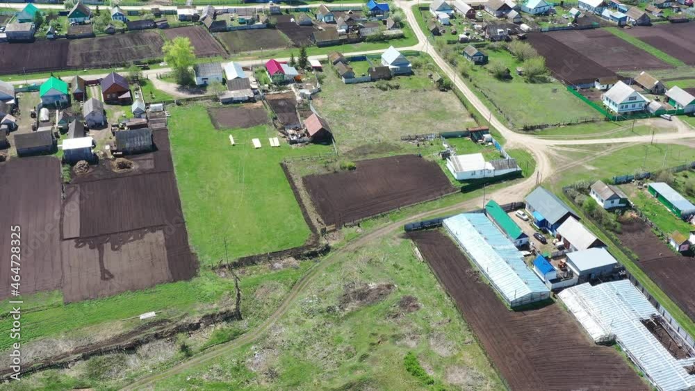 Aerial view of russian village with small farm lands for home gardening during sunny day in spring season Aerial view of russian village with small farm lands for home gardening during sunny day in spring season