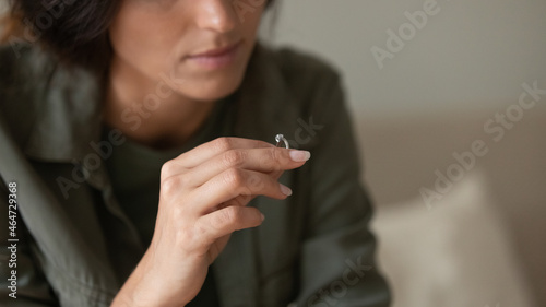 Obraz na plátně Depressed sad young woman taking off and holding wedding ring
