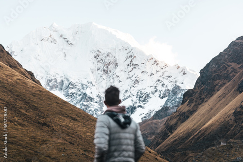 Blurred out man looking up at mountain peaks