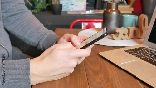 Young man using mobile phone and laptop at cafe