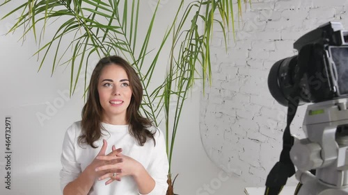 Beautiful female blogger talks recording new vlog at home