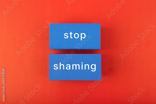 Stop shaming minimal concept. Minimal flat lay with text on blue rectangles on bright red background