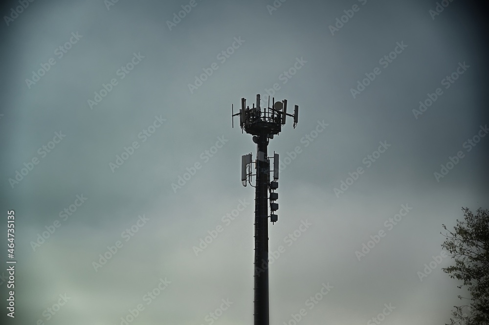 telecommunications antennas tower silhouette under dull sky