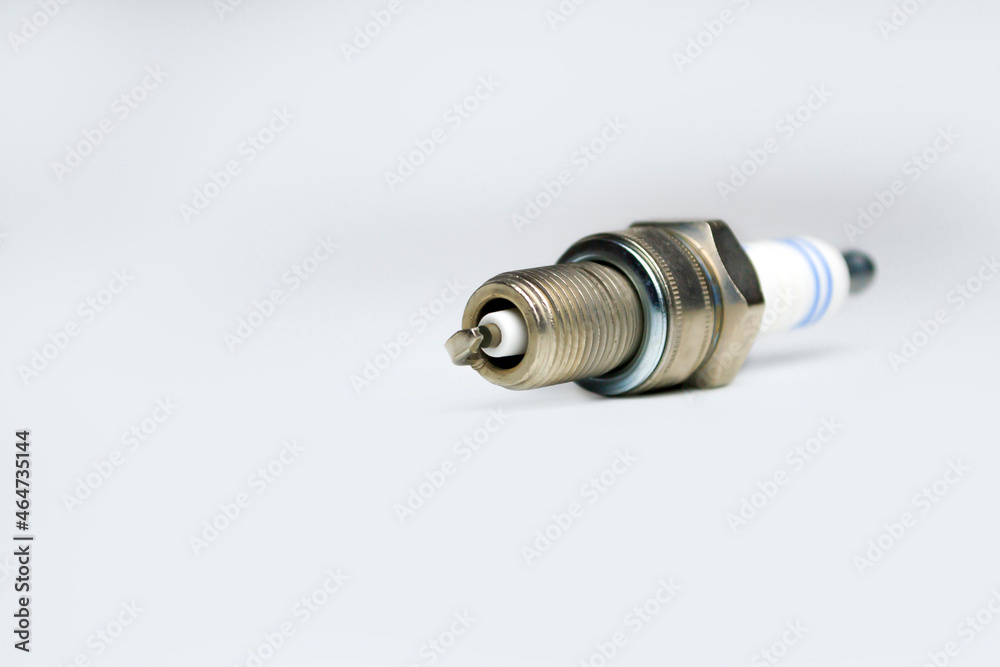 Auto service. New car spark plug as spare part of auto transportation on gray background. Auto service. New car spark plug as spare part of auto transportation on gray background.