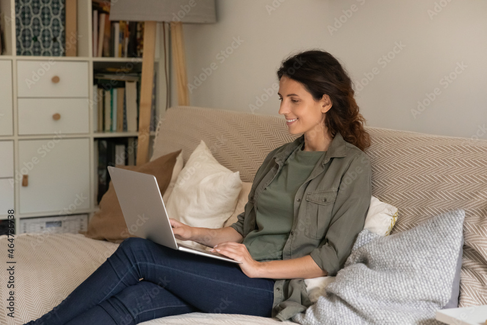 Happy female student, remote employee studying or working from home, resting on couch, using laptop for video call, watching webinar, talking to client, meeting with colleague on conference online Happy female student, remote employee studying or working from home, resting on couch, using laptop for video call, watching webinar, talking to client, meeting with colleague on conference online