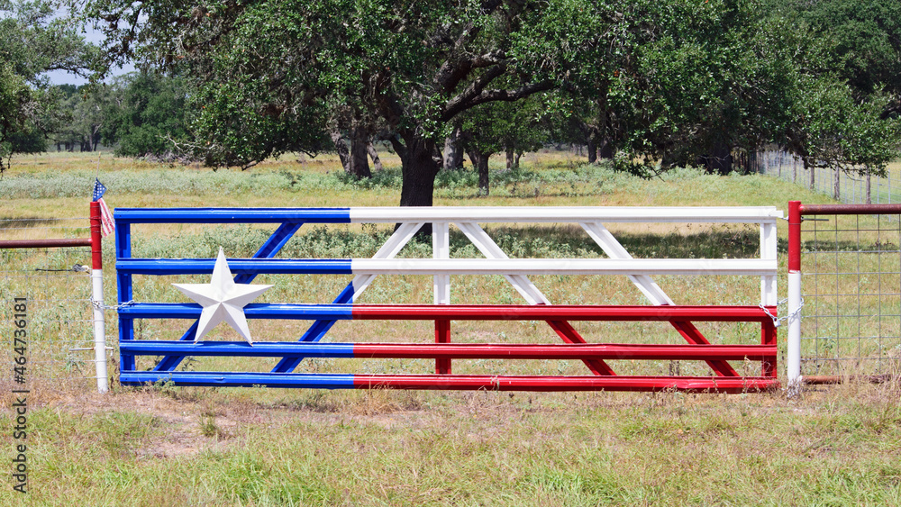 Texas Star on a Fence in the field with Texas Flag painted on metal fence with big oak tree in background. Texas Star on a Fence in the field with Texas Flag painted on metal fence with big oak tree in background.