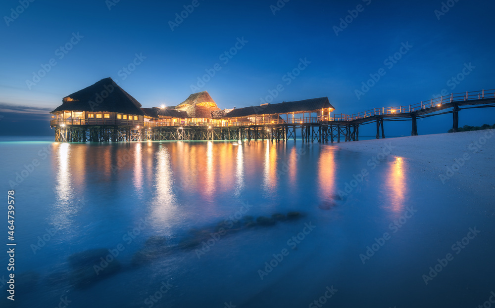 Beautiful wooden restaurant on the water in summer night