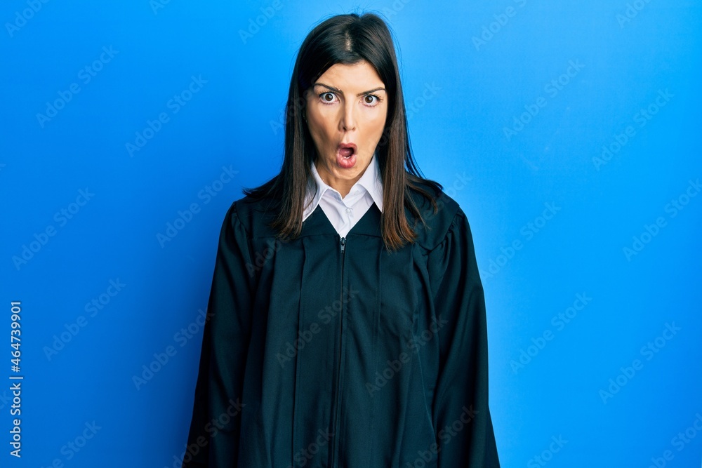 Young hispanic woman wearing judge uniform afraid and shocked with surprise expression, fear and excited face. Young hispanic woman wearing judge uniform afraid and shocked with surprise expression, fear and excited face.