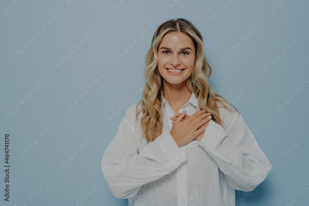 Relieved blonde woman with hands on her chest Relieved blonde woman with hands on her chest