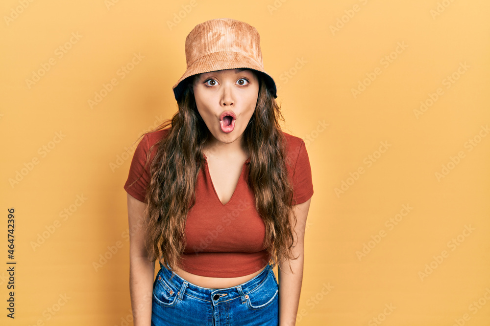Young hispanic girl wearing casual clothes and hat afraid and shocked with surprise expression, fear and excited face. Young hispanic girl wearing casual clothes and hat afraid and shocked with surprise expression, fear and excited face.