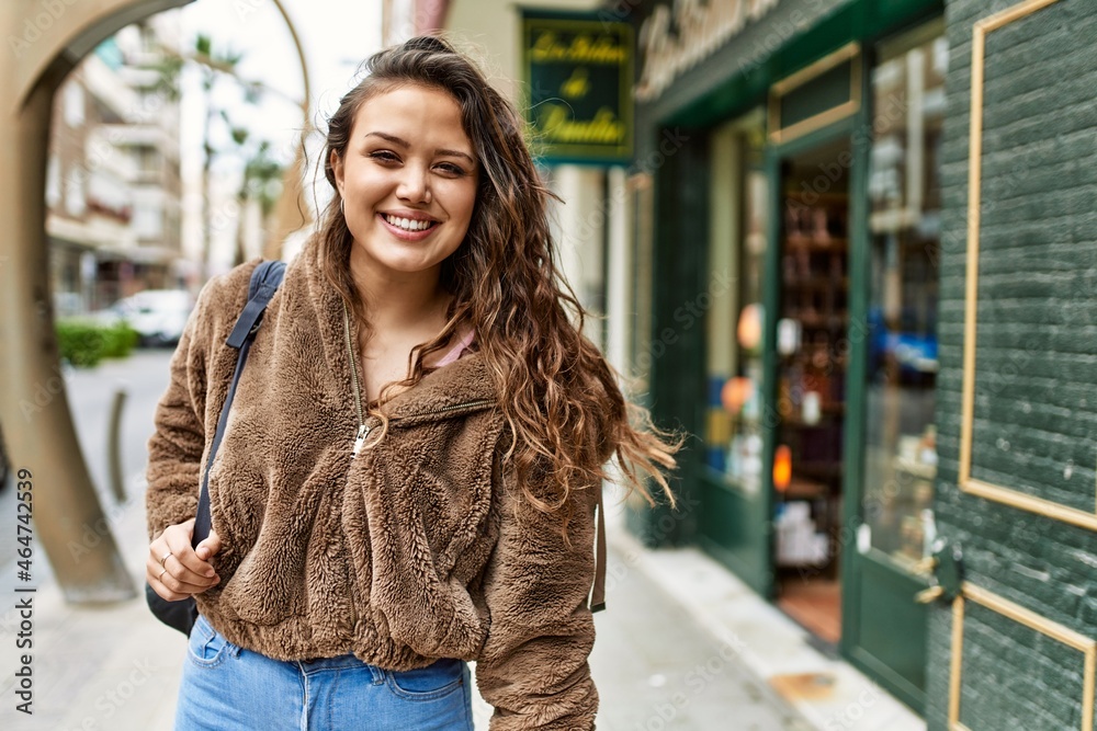 Fototapeta premium young hispanic girl smiling happy standing at the city.