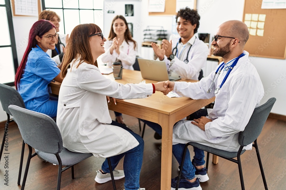 Fototapeta premium Group of doctor smiling and clapping to partners handshake in a medical meeting at the clinic office.