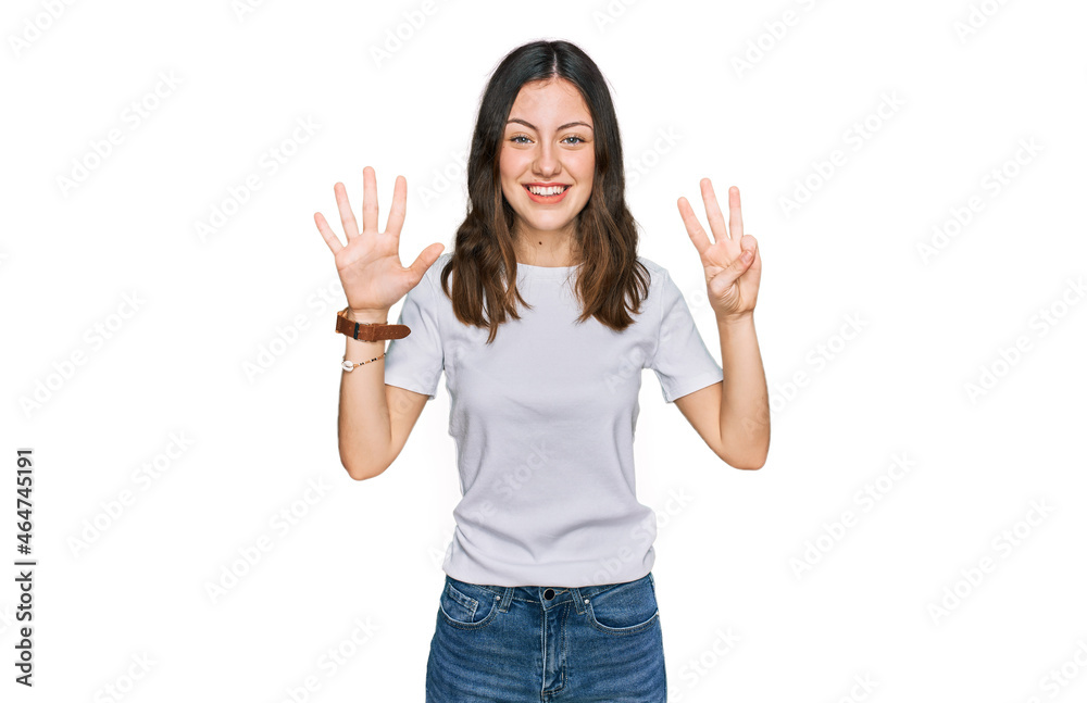 Young beautiful woman wearing casual white t shirt showing and pointing up with fingers number eight while smiling confident and happy. Young beautiful woman wearing casual white t shirt showing and pointing up with fingers number eight while smiling confident and happy.
