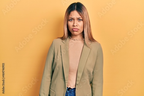 Beautiful hispanic woman wearing business jacket skeptic and nervous, frowning upset because of problem. negative person.