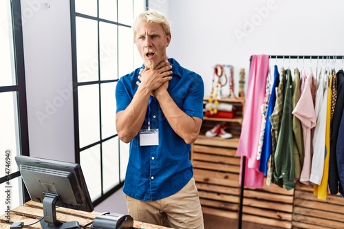 Young blond man working as manager at retail boutique shouting and suffocate because painful strangle. health problem. asphyxiate and suicide concept.