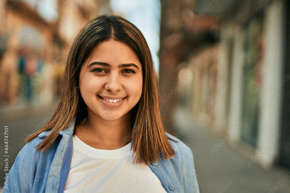 Young latin girl smiling happy standing at the city.