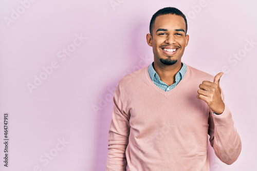 Young african american man wearing elegant clothes smiling happy and positive, thumb up doing excellent and approval sign