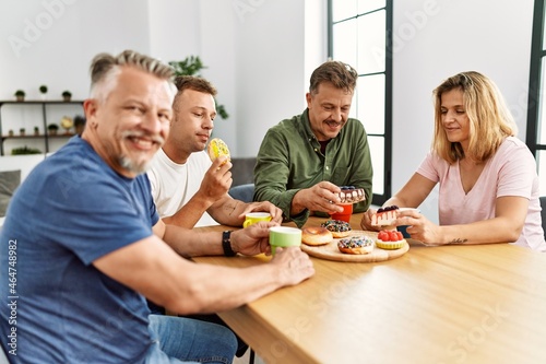 Group of middle age friends having breakfast sitting on the table at home.