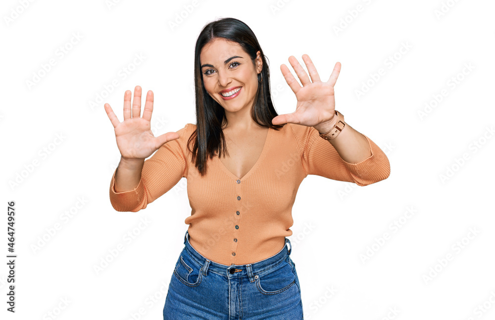 Young hispanic woman wearing casual clothes showing and pointing up with fingers number ten while smiling confident and happy. Young hispanic woman wearing casual clothes showing and pointing up with fingers number ten while smiling confident and happy.