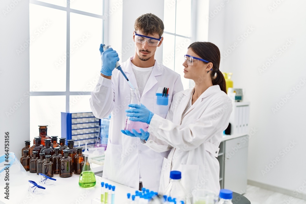 Man and woman partners wearing scientist uniform holding test tube and ...