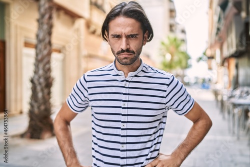 Young hispanic man with beard outdoors at the city skeptic and nervous  frowning upset because of problem. negative person.