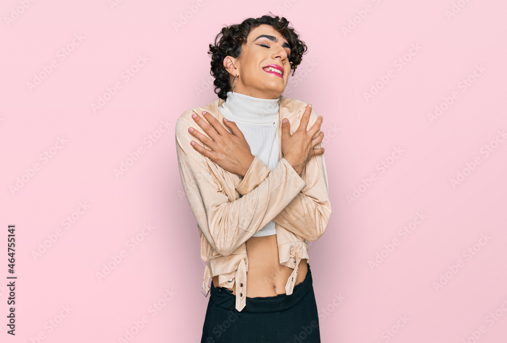 Handsome man wearing make up and woman clothes hugging oneself happy and positive, smiling confident. self love and self care Handsome man wearing make up and woman clothes hugging oneself happy and positive, smiling confident. self love and self care