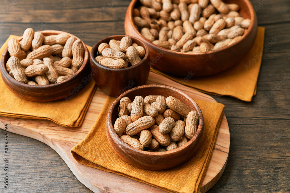 Image of bunch of peanuts in a bowl on a wooden table Image of bunch of peanuts in a bowl on a wooden table