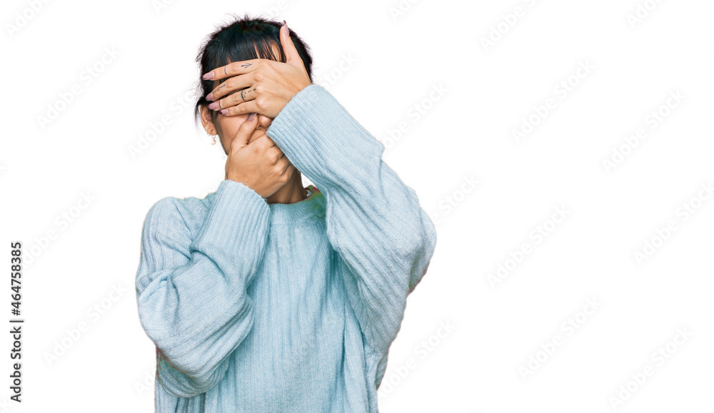 Young hispanic woman wearing casual clothes covering eyes and mouth with hands, surprised and shocked. hiding emotion Young hispanic woman wearing casual clothes covering eyes and mouth with hands, surprised and shocked. hiding emotion