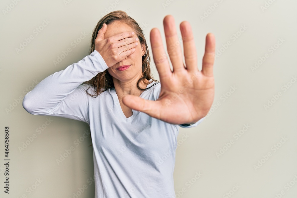 Young blonde woman wearing casual clothes covering eyes with hands and doing stop gesture with sad and fear expression. embarrassed and negative concept. Young blonde woman wearing casual clothes covering eyes with hands and doing stop gesture with sad and fear expression. embarrassed and negative concept.