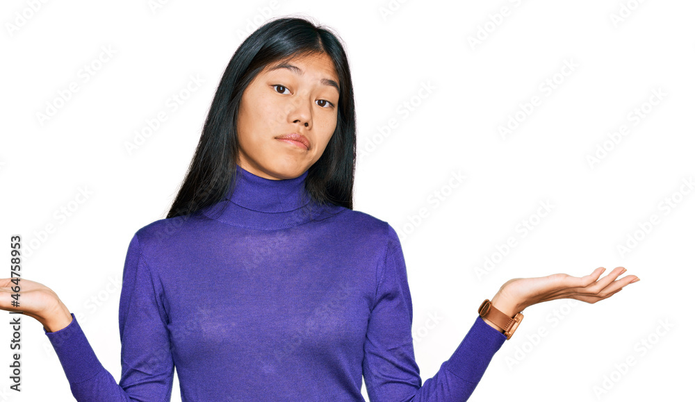 Beautiful young asian woman wearing casual clothes clueless and confused expression with arms and hands raised. doubt concept. Beautiful young asian woman wearing casual clothes clueless and confused expression with arms and hands raised. doubt concept.